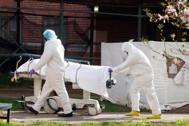 Healthcare workers push a stretcher holding a deceased persons on it at Kingsbrook Jewish Medical Center during the outbreak of the coronavirus disease (COVID19) in the Brooklyn borough of New York