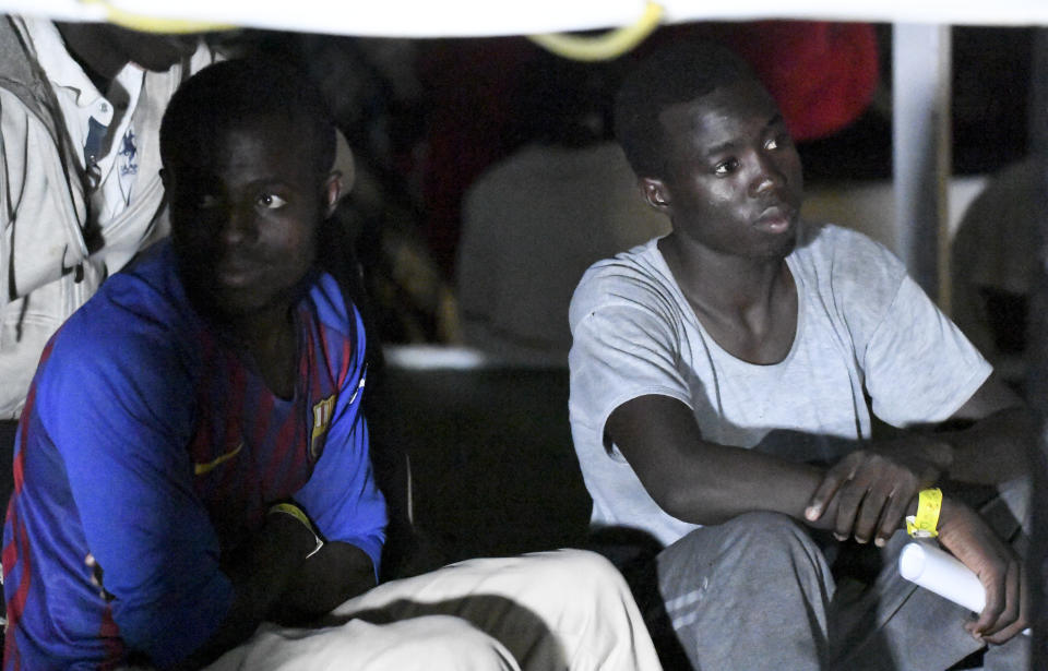 Migrants on the Open Arms rescue ship before disembarking on the Sicilian island of Lampedusa, southern Italy, Tuesday, Aug. 20, 2019. An Italian prosecutor ordered the seizure of a rescue ship and the immediate evacuation of more than 80 migrants still aboard, capping a drama Tuesday that saw 15 people jump overboard in a desperate bid to escape deteriorating conditions on the vessel and Spain dispatch a naval ship to try to resolve the crisis. (AP Photo/Salvatore Cavalli)