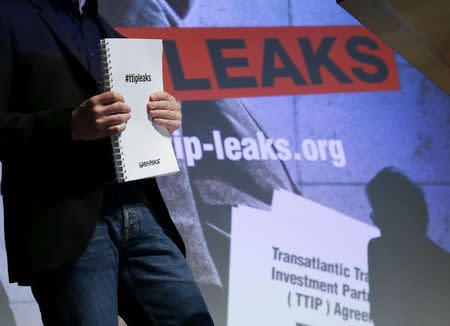 Volker Gassner of the environmental campaign group Greenpeace holds a copy of the leaked TTIP negotiations during a news conference in Berlin, Germany, May 2, 2016. REUTERS/Fabrizio Bensch