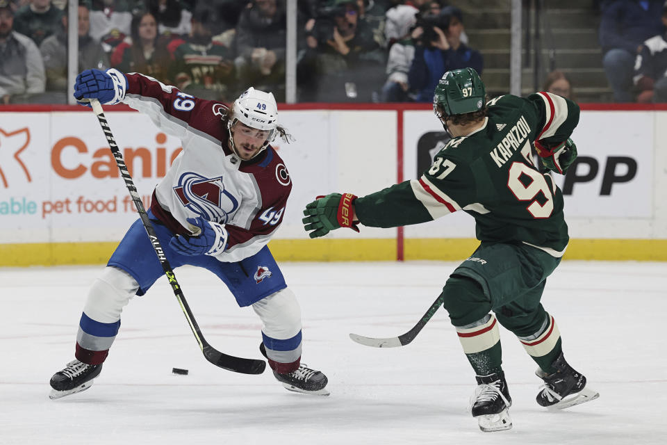 Colorado Avalanche defenseman Samuel Girard (49) handles the puck against Minnesota Wild left wing Kirill Kaprizov (97) during the second period of an NHL hockey game Monday, Oct. 17, 2022, in St. Paul, Minn. (AP Photo/Stacy Bengs)