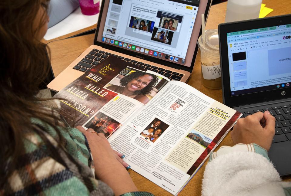 Cold case students review the April 18 issue of People magazine, which featured their work on the 2010 murder of Alicia Jackson in Columbus.