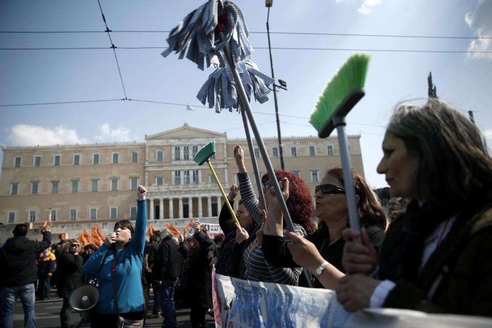 Protesting cleaning staff fired by the Finance Ministry marched holding up buckets and mops during a rally outside the Greek parliament in central Athens on Wednesday, March 12, 2014. A 24-hour strike by civil servants disrupted public services in Greece Wednesday as the country’s government struggled to hammer out a deal on further austerity measures with international creditors. Thousands of protesters attended rallies in Athens and other Greek cities, while civil servants have penciled in another 48-hour strike on March 19-20. (AP Photo/Petros Giannakouris)