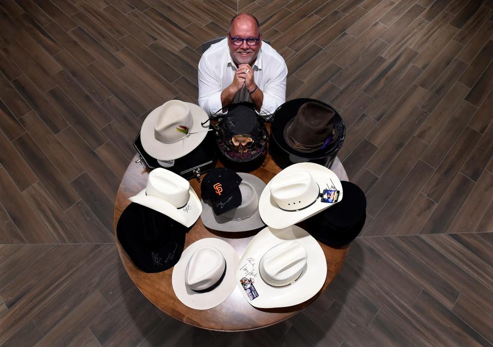 Longtime Nashville music industry executive Chaz Corzine sits with his hat collection from celebrities on Monday, July 17, 2023, in Nashville, Tenn. Corzine, executive director of the Fisher Center of the Performing Arts at Belmont University, is donating the hats from various artists including Slash, Alice Cooper, George Jones and Michael Jackson to the auction for St. Jude Children’s Research Hospital. His daughter Mallory had a life-saving brain tumor removal surgery at St. Jude when she was 8 years old.