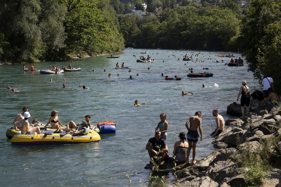 People swim and sail on inflatable boats, on the Aare River, during the sunny and warm weather, in Bern, Switzerland, Sunday, Aug. 20, 2023. Many parts of Switzerland have been experiencing a period of extreme heat. (Anthony Anex/Keystone via AP) ORG XMIT: LBJ133