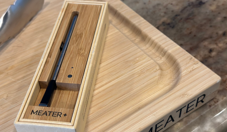 Meater Plus thermometer in box on top of Meater cutting board