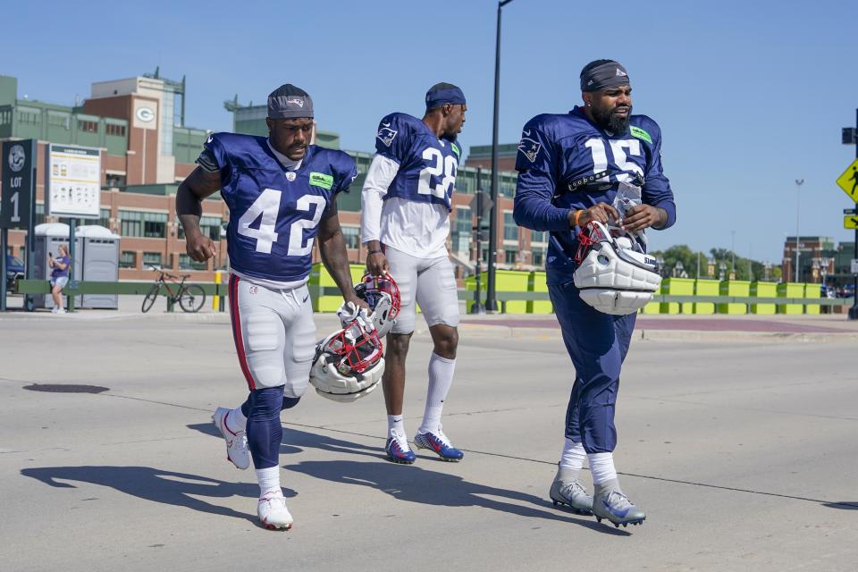 New England Patriots' Ezekiel Elliott along with J.J. Taylor (42) and Ameer Speed (28) walk to practice for NFL football training camp Wednesday, Aug. 16, 2023, in Green Bay, Wis. (AP Photo/Morry Gash)