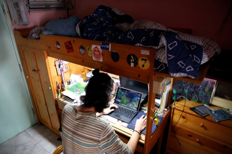 Derek Tai plays a computer game at his apartment in Hong Kong