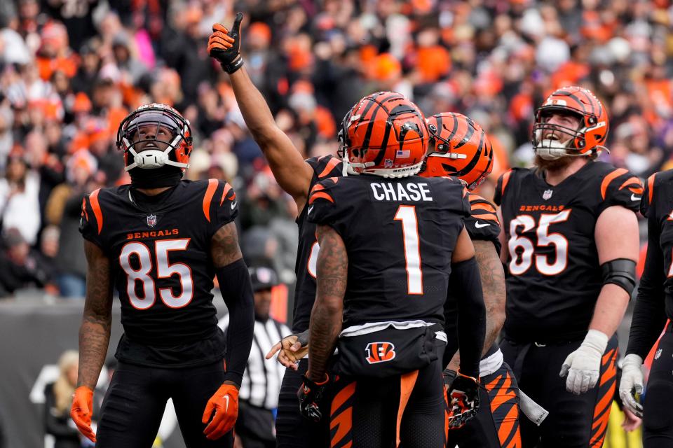 Cincinnati Bengals running back Joe Mixon (28) pulls a coin from his first band and flips it in the end zone after running in a touchdown in the first quarter of the NFL Week 18 game between the Cincinnati Bengals and the Baltimore Ravens at Paycor Stadium in downtown Cincinnati on Sunday, Jan. 8, 2023. The Bengals led 24-7 at halftime.