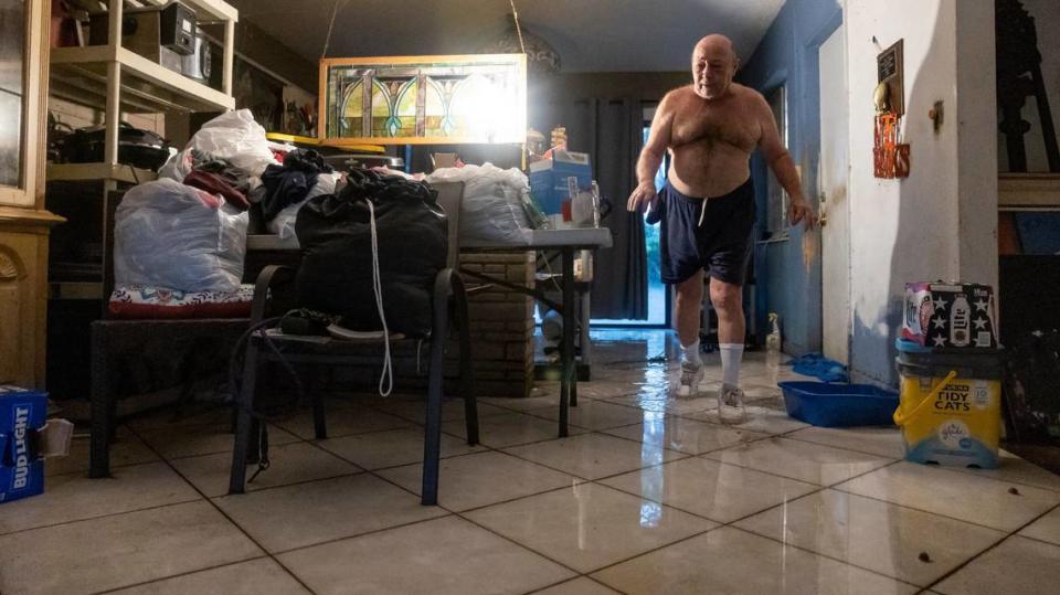 Sam Demarco makes his way through his wet living room after a heavy downpour flooded his home on Wednesday, June 12, 2024, in Hollywood, Florida.