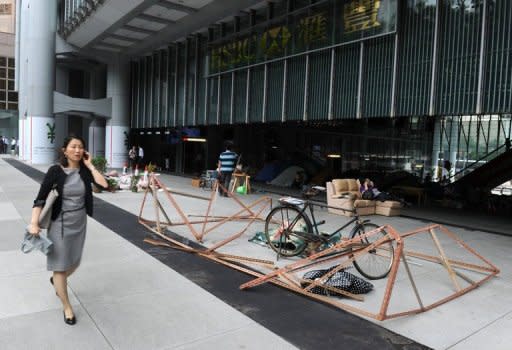 A pedestrian walks past a display by the anti-capitalist 'Occupy' movement in Hong Kong, on the ground level of the HSBC building in Hong Kong, on June 25. HSBC on Monday sought legal permission to evict the protesters, one of the last remnants of the 'Occupy' movement in Asia