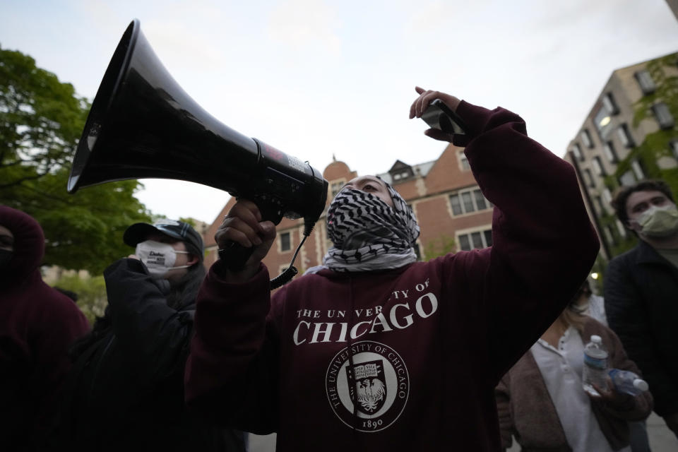 A pro-Palestinian protester leads chants at the university's police as they are kept from the university's quad while the student encampment is dismantled at the University of Chicago, on Tuesday, May 7, 2024, in Chicago. (AP Photo/Charles Rex Arbogast)