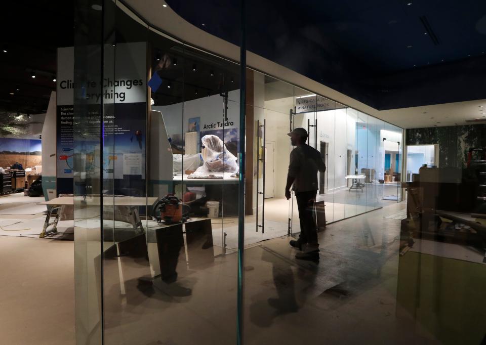 A worker moves between spaces as renovations are underway at the Delaware Museum of Nature and Science in early April, 2022.