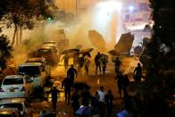 Anti-government demonstrators run from a water cannon during clashes with police near the Hong Kong Polytechnic University (PolyU) in Hong Kong