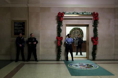 Police stand outside Chicago Mayor Rahm Emanuel's office as protesters demonstrate at City Hall in Chicago, Illinois, United States, December 31, 2015. REUTERS/Alex Wroblewski