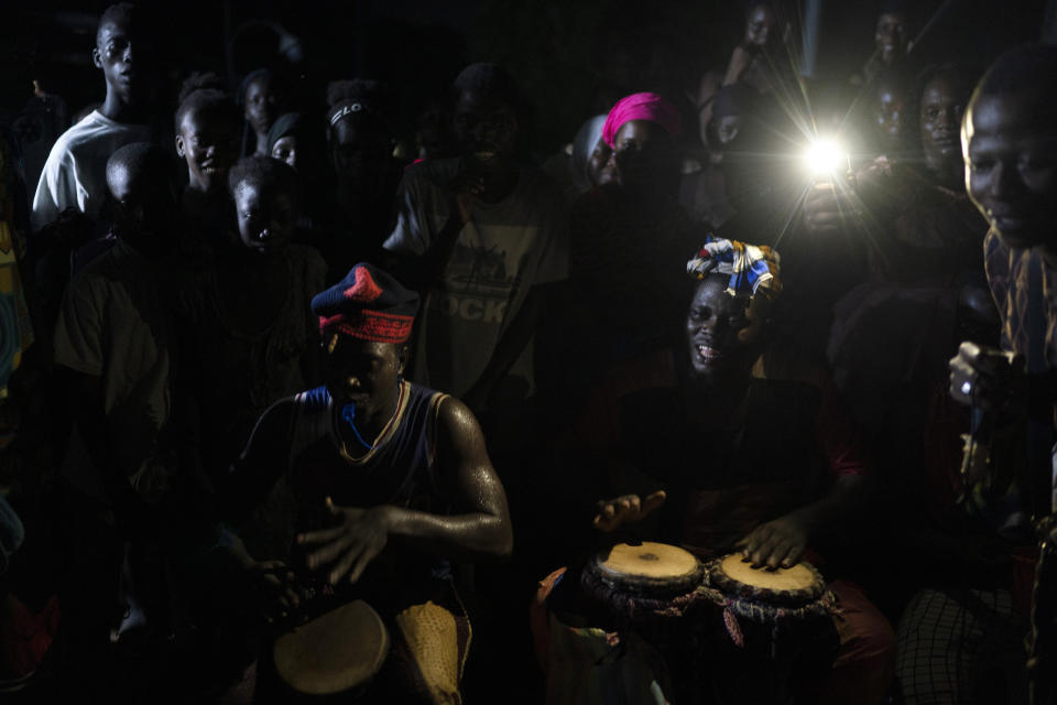Musicians perform the Mandinka drums during the Kankurang ritual in Bakau, Gambia, Saturday, Oct. 2, 2021. The Kankurang rite was recognized in 2005 by UNESCO, which proclaimed it a cultural heritage. Despite his fearsome appearance, the Kankurang symbolizes the spirit that provides order and justice and is considered a protector against evil. He appears at ceremonies where circumcised boys are taught cultural practices, including discipline and respect. (AP Photo/Leo Correa)