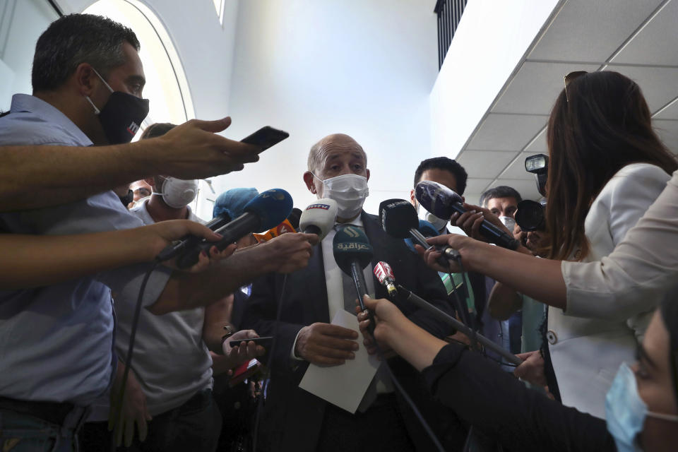 French Foreign Minister Jean-Yves Le Drian, wearing a mask to help prevent the spread of the coronavirus, speaks to journalists during his visit to the Carmel Saint Joseph school in Mechref district, south of the capital Beirut, Lebanon, Friday, July 24, 2020. Le Drian pledged on Friday € 15 million ($ 17 million) in aid to Lebanon's schools, struggling under the weight of the country's major economic crisis. (AP Photo/Bilal Hussein)