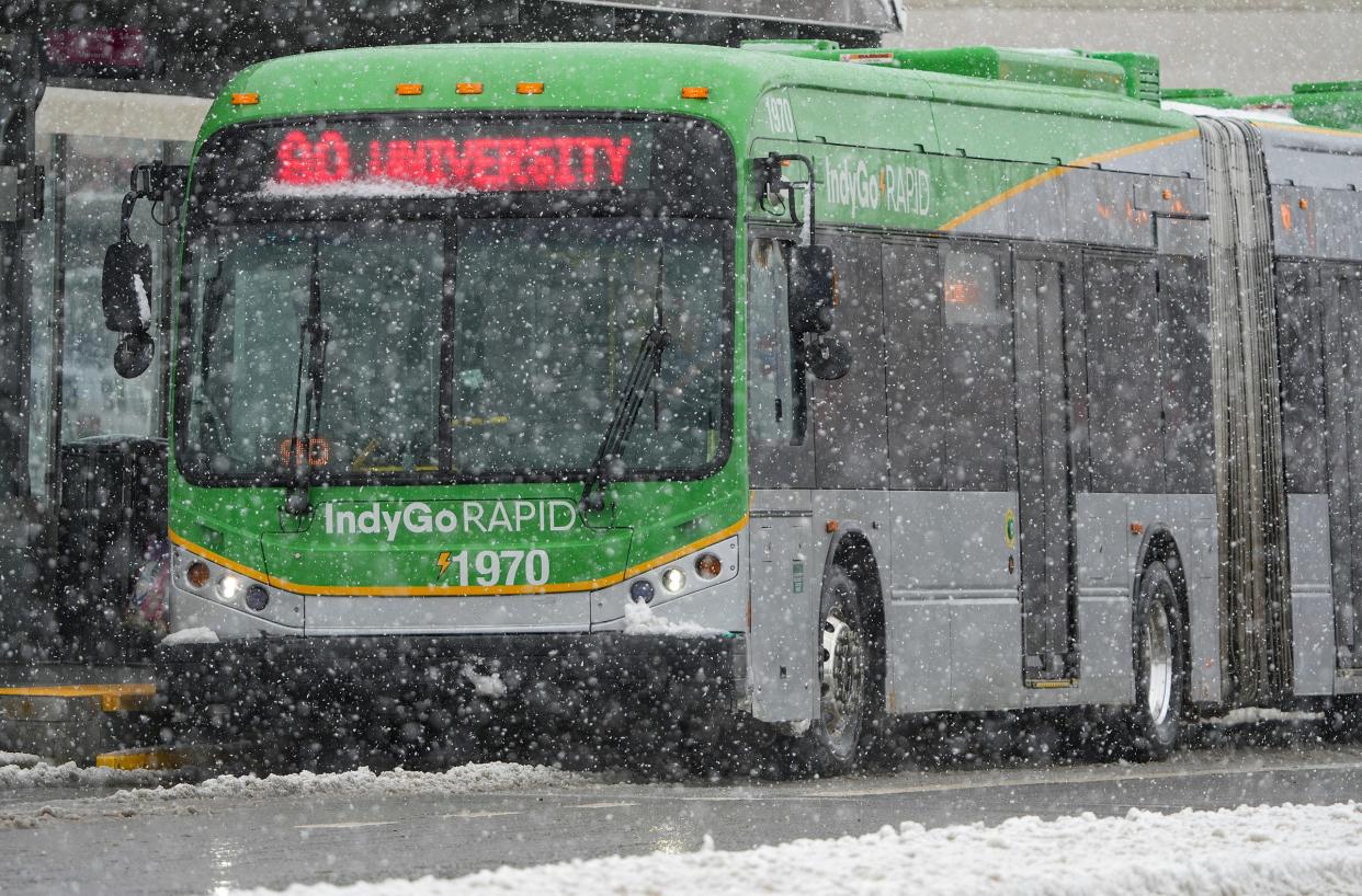 An IndyGo bus picks up passengers on Wednesday, Jan. 25, 2023, in the Garfield Park neighborhood of Indianapolis. The city had only received about 3 inches of snow by early afternoon according to the National Weather Service, and wouldn't receive much more, due to melting, compacting snow and just-above-freezing temperatures. 