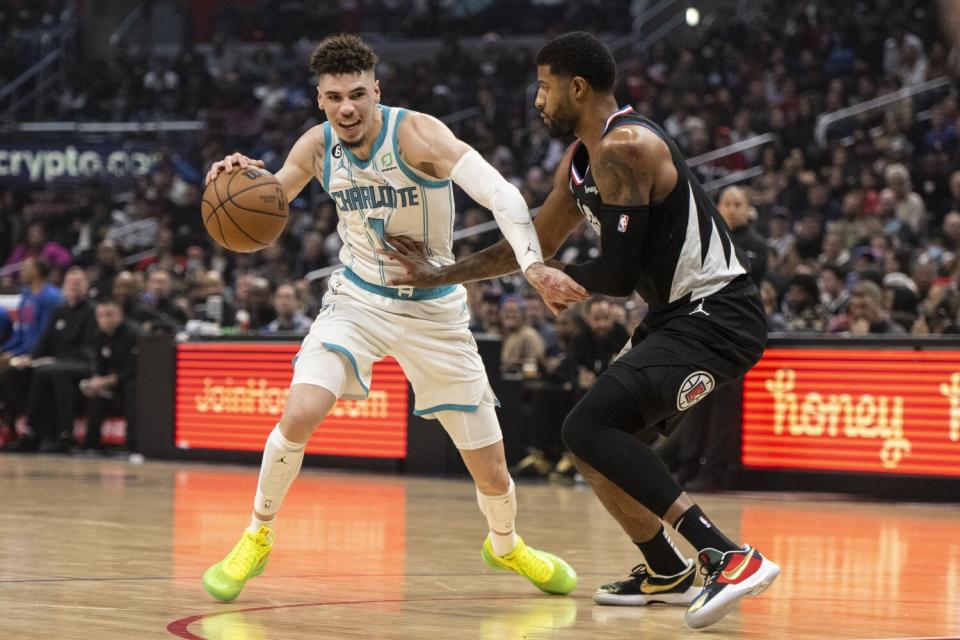 Charlotte Hornets guard LaMelo Ball drives as Clippers guard Paul George defends.