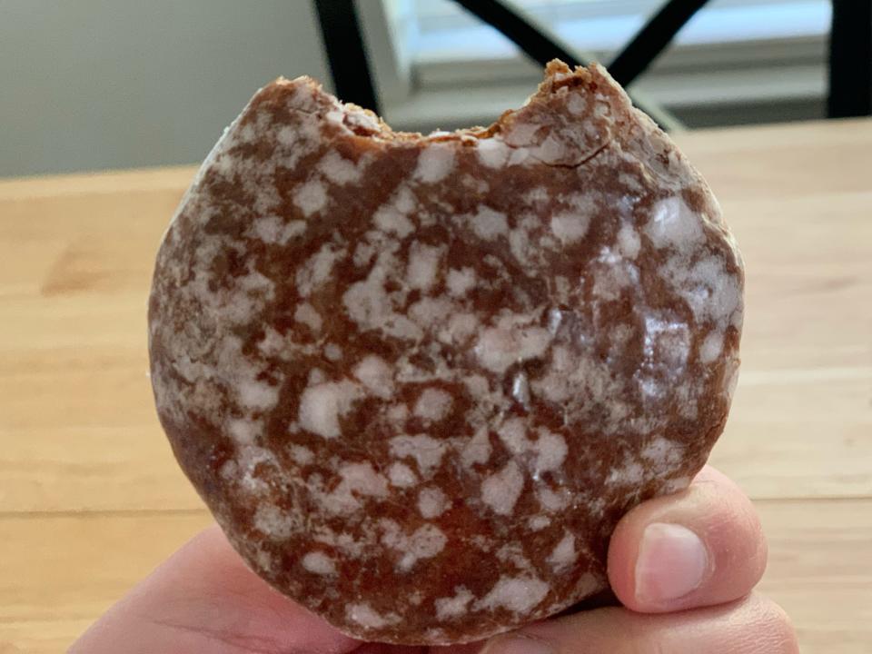 hand holding trader joes lebkuchen cookie with bite taken out of it