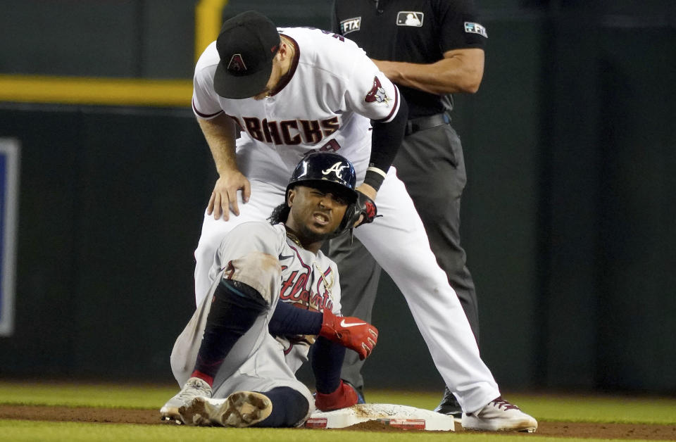 Atlanta Braves' Ozzie Albies, bottom, reacts after being tagged out by Arizona Diamondbacks second baseman Josh VanMeter, top, during the fifth inning of a baseball game Thursday, Sept 23, 2021, in Phoenix. (AP Photo/Darryl Webb)