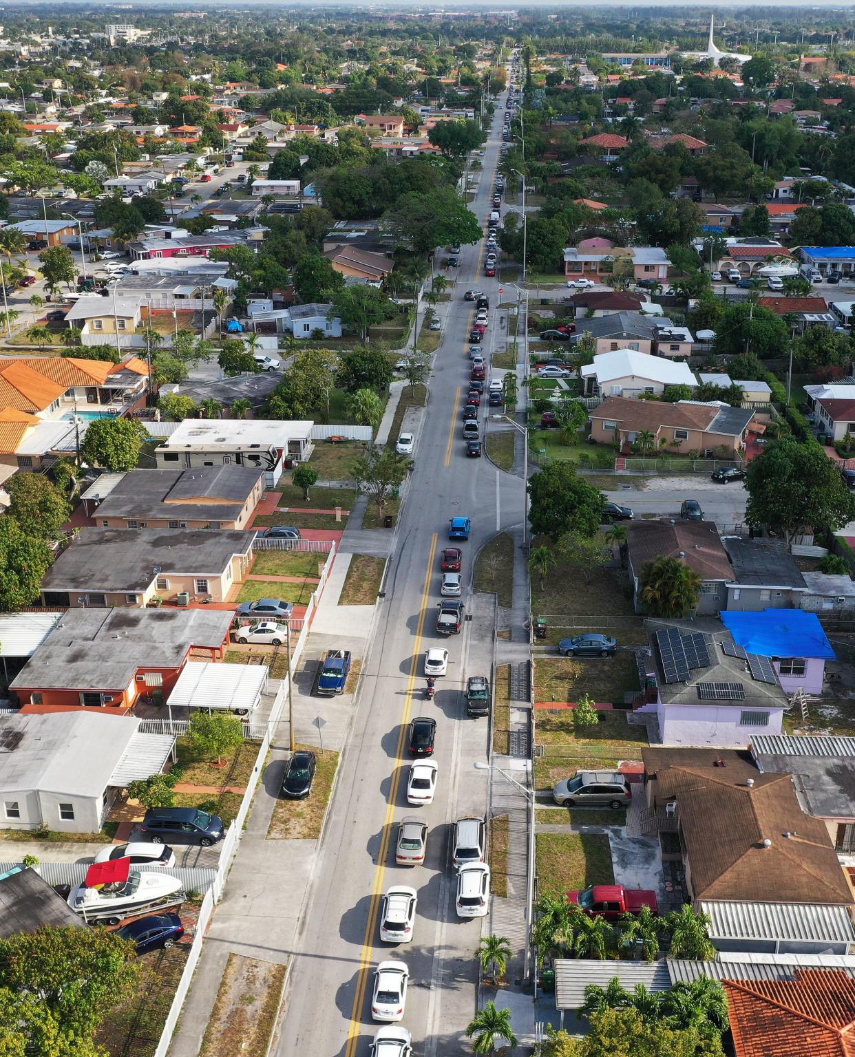 An aerial view from a drone shows vehicles lining up to receive unemployment applications being given out by City of Hialeah employees in front of the John F. Kennedy Library on April 8, 2020, in Hialeah, Fla. The city is distributing the printed unemployment forms to residents as people continue to have issues with access to the state of Florida’s unemployment website in the midst of widespread layoffs due to businesses closing during the coronavirus pandemic.