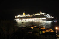 A photograph taken early on January 14, 2012 of the Costa Concordia after the cruise ship with more than 4,000 people on board ran aground and keeled over off the Isola del Giglio, and Italian island, last night. Three people died and several were missing Saturday after a cruise ship with more than 4,000 people on board ran aground and keeled over off an Italian island, sparking chaos as passengers scrambled to get off. The ship was on a cruise in the Mediterranean, leaving from Savona with planned stops in Civitavecchia, Palermo, Cagliari, Palma, Barcelona and Marseille," the company said. AFP PHOTO / LUCA MILANO