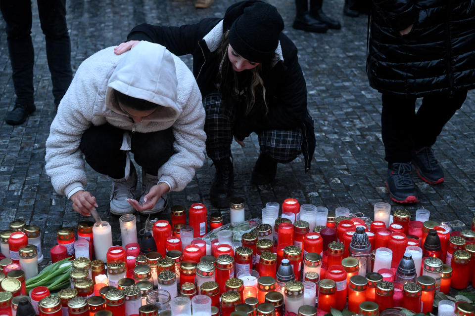 A young woman lights a candle at a makeshift memorial for the victims outside the Charles University in central Prague on Dec. 22, 2023, as police investigators kept working on the campus the day after a deadly mass shooting. / Credit: Michal CIZEK / AFP via Getty Images