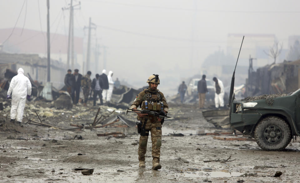 An Afghan security force walks around the site of suicide bomb attack in Kabul, Afghanistan, Thursday, Nov. 29, 2018. Taliban insurgents staged a coordinated attack targeting a security firm in the Afghan capital on Wednesday, killing people and wounding others. (AP Photo/Rahmat Gul)