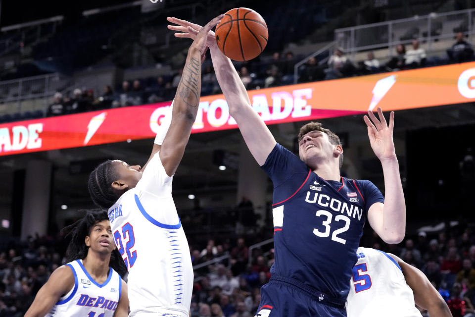 DePaul guard Elijah Fisher, left, and UConn center Donovan Clingan battle for a rebound during the first half of an NCAA college basketball game in Chicago, Wednesday, Feb. 14, 2024. (AP Photo/Nam Y. Huh)