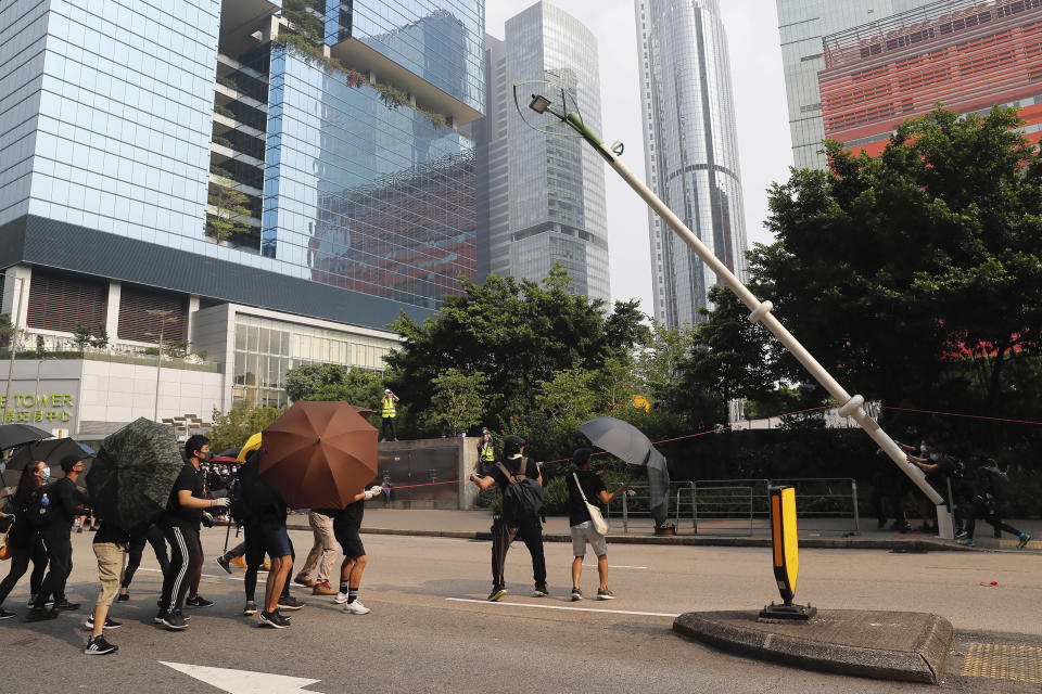Demonstrators try to pull down a smart lamppost during a protest in Hong Kong, Saturday, Aug. 24, 2019. Chinese police said Saturday they released an employee at the British Consulate in Hong Kong as the city's pro-democracy protesters took to the streets again, this time to call for the removal of "smart lampposts" that raised fears of stepped-up surveillance. (AP Photo/Kin Cheung)