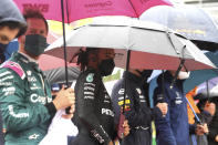 Drivers stand under umbrellas prior to the Formula One Grand Prix at the Spa-Francorchamps racetrack in Spa, Belgium, Sunday, Aug. 29, 2021. (John Thys, Pool Photo via AP)
