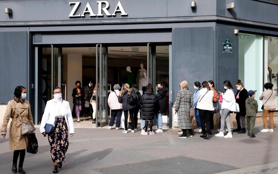 Customers queue in front of the entrance to a Zara  - Getty