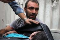 A Syrian man carries the body of his nephew following a reported airstrike on the city of Aleppo