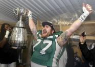 The Saskatchewan Roughriders Dan Clark celebrates with the Grey Cup after they defeated the Hamilton Tiger-Cats in the CFL's 101st Grey Cup championship football game in Regina, Saskatchewan November 24, 2013. REUTERS/Mark Blinch (CANADA - Tags: SPORT FOOTBALL)