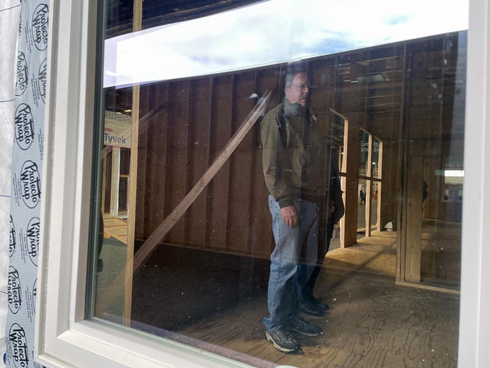 Scott Benedict checks out the inside of the mass timber affordable housing prototype that will soon become his new home while at the Port of Portland, Friday, Jan. 27, 2023 in Portland, Ore. Scott and Barbara Benedict lost their home in the 2020 Labor Day wildfires that devastated southern Oregon and destroyed thousands of homes. (AP Photo/Claire Rush)