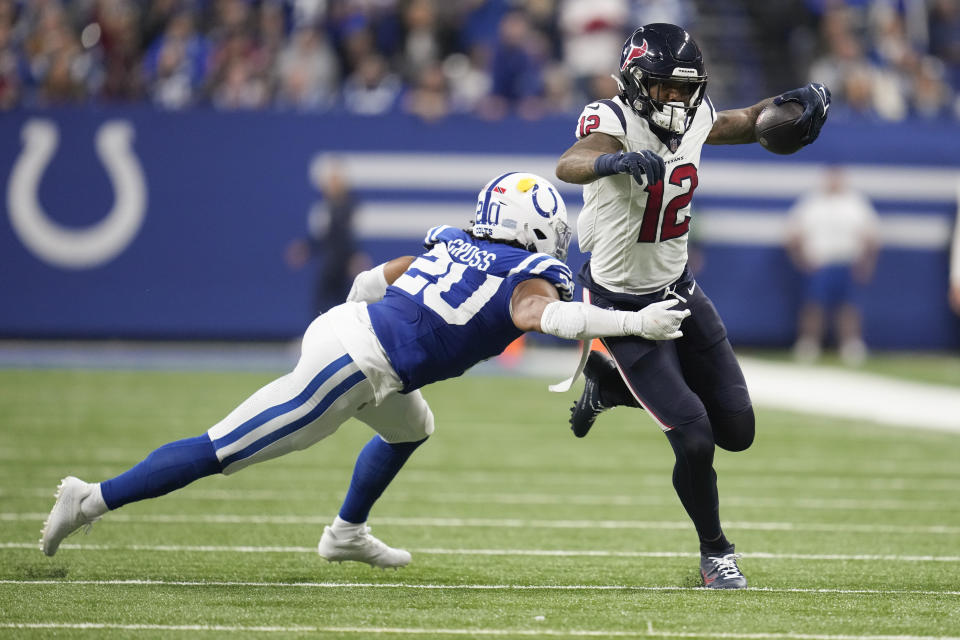 Houston Texans wide receiver Nico Collins (12) runs after a catch as Indianapolis Colts safety Nick Cross (20) closes in during the first half of an NFL football game Saturday, Jan. 6, 2024, in Indianapolis. (AP Photo/Michael Conroy)