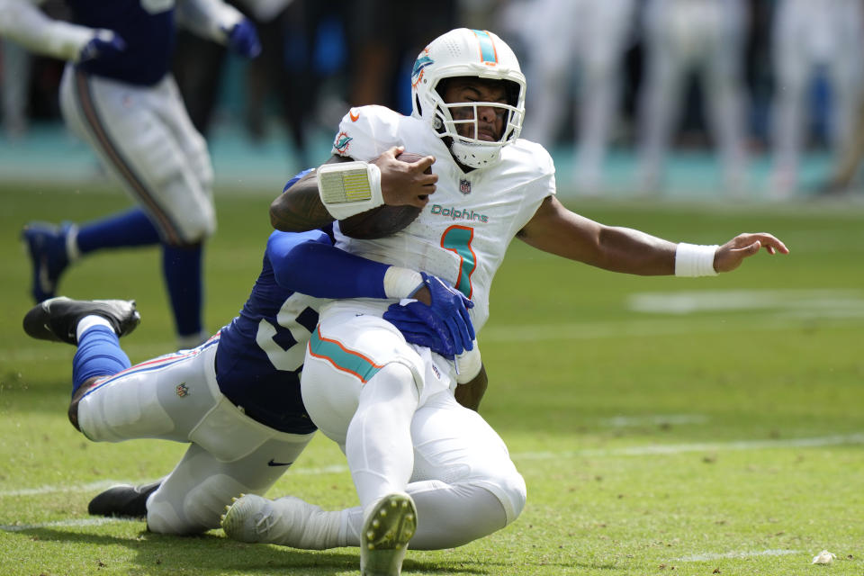 New York Giants linebacker Darren Waller (58) bring down Miami Dolphins quarterback Tua Tagovailoa (1) during the first half of an NFL football game, Sunday, Oct. 8, 2023, in Miami Gardens, Fla. (AP Photo/Wilfredo Lee)