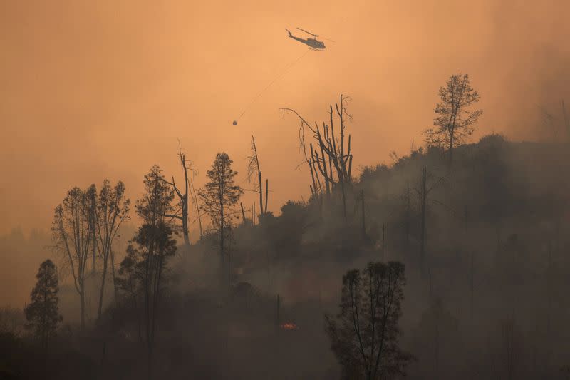 FILE PHOTO: FILE PHOTO: Helicopter releases water on secition of LNU Lightning Complex Fire near Middletown, California