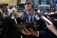 Trader Gregory Rowe, center, works on the floor of the New York Stock Exchange, Tuesday, Jan. 17, 2017. Stocks are opening slightly lower on Wall Street, led by declines in banks and health care companies. (AP Photo/Richard Drew)