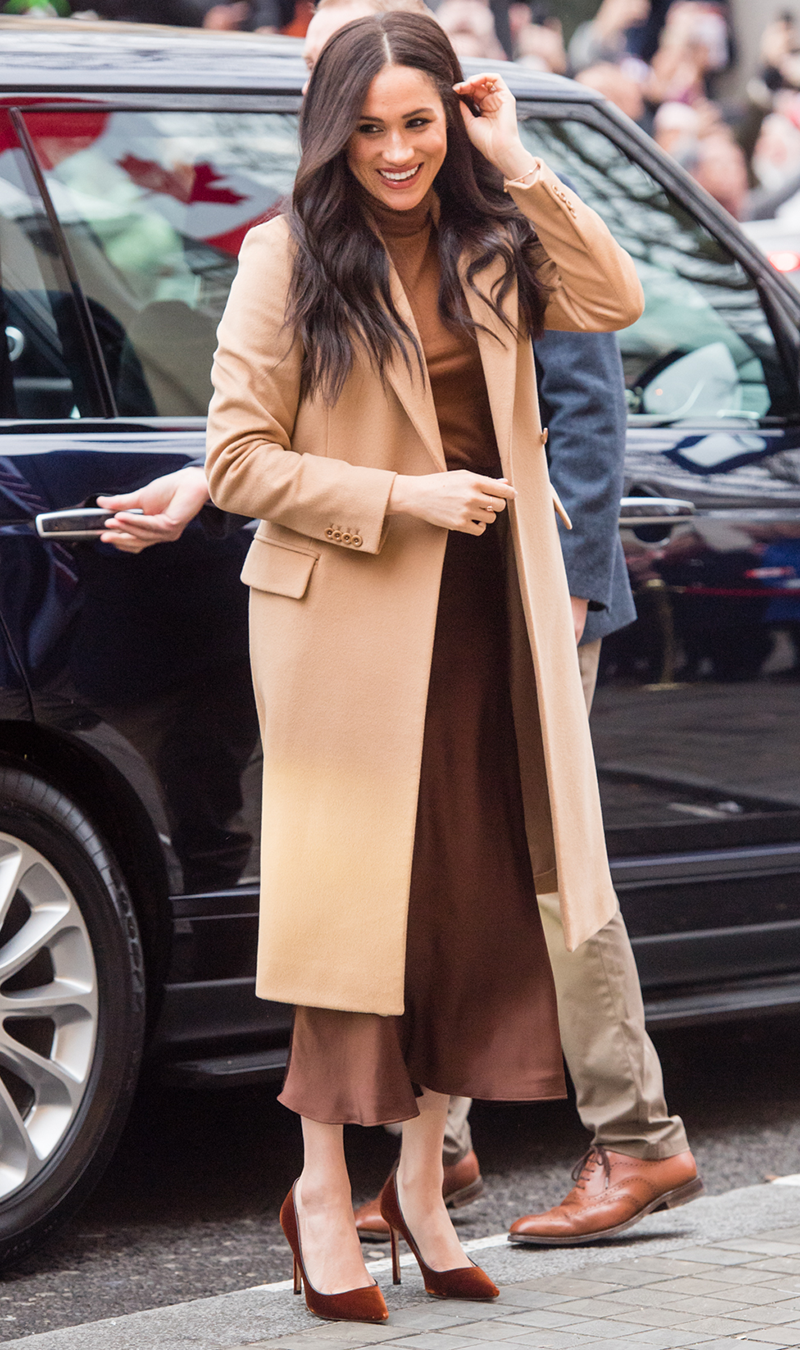 <p>The <a href="https://www.cosmopolitan.com/uk/fashion/celebrity/a30429860/meghan-markle-camel-coat/" rel="nofollow noopener" target="_blank" data-ylk="slk:camel coat" class="link ">camel coat</a> is a royal staple and Meghan's Reiss style is utterly timeless. The Duchess wore the piece over a silky chocolate slip skirt, caramel jumper, complete with a pair of bronze velvet heels.</p>