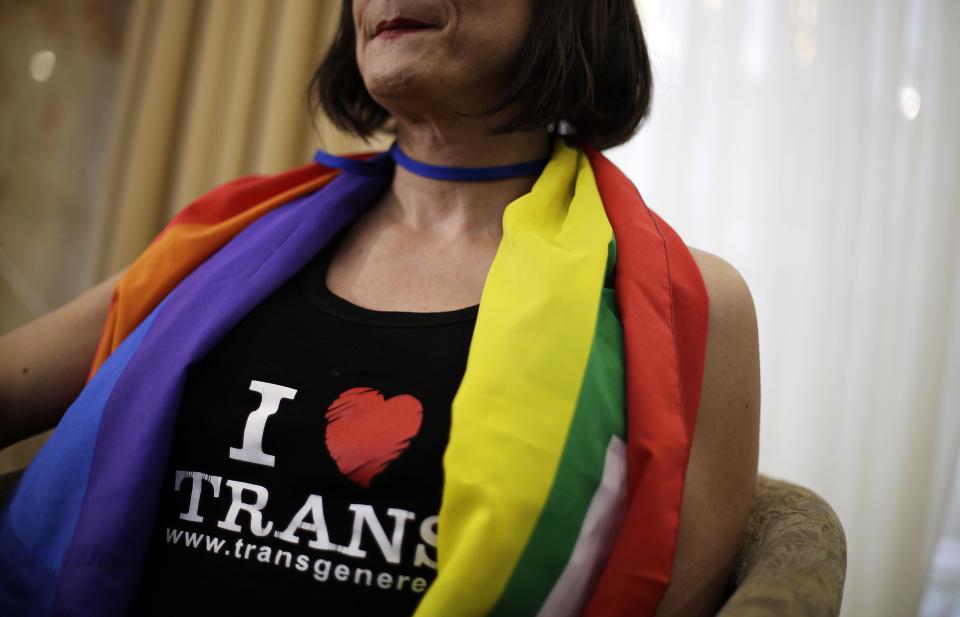 Vladimir Luxuria, a former Communist lawmaker in the Italian parliament and prominent crusader for transgender rights, wears a pro-transgender t-shirt as she sits for an interview, Monday, Feb. 17, 2014, in central Sochi, Russia, home of the 2014 Winter Olympics. Luxuria said she was detained by police at the Olympics after being stopped while carrying a rainbow flag that read in Russian: "Gay is OK." Police on Monday denied this happened. (AP Photo/David Goldman)