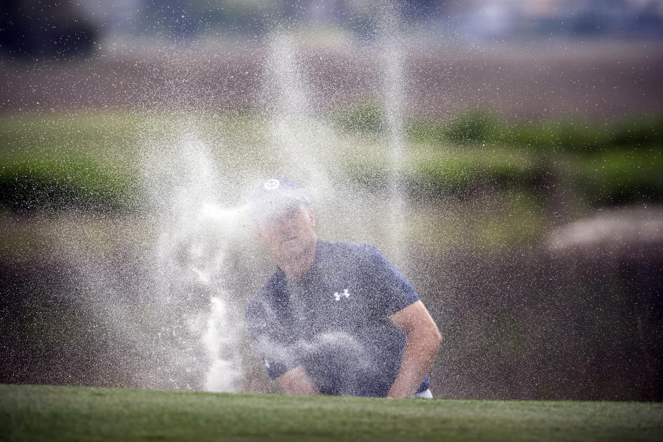 Jordan Spieth watches his shot out of the bunker on the 18th hole from behind a cloud of sand during a one-hole playoff with Patrick Cantlay at the RBC Heritage golf tournament, Sunday, April 17, 2022, in Hilton Head Island, S.C. (AP Photo/Stephen B. Morton)