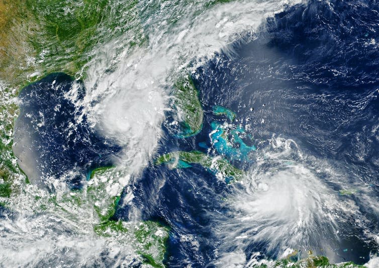 A satellite image of Florida and the Caribbean with two hurricanes.