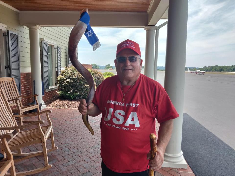 Georgian Robert Weinger, wearing Trump 2020 t-shirt and Trump 2024 ball cap, holds a ceremonial shofar horn in his right hand while posing for a photo May 20 at a David Perdue for governor rally in Augusta, Georgia.