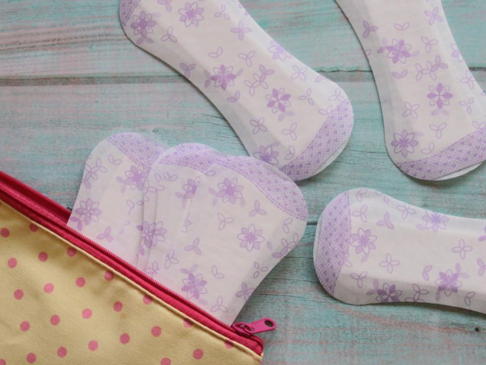 Panty liners in and around a yellow toiletry bag