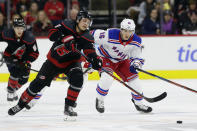 Carolina Hurricanes center Sebastian Aho, left, of Finland, skates for the puck against New York Rangers center Ryan Strome (16) during the second period of an NHL hockey game in Raleigh, N.C., Friday, Feb. 21, 2020. (AP Photo/Gerry Broome)