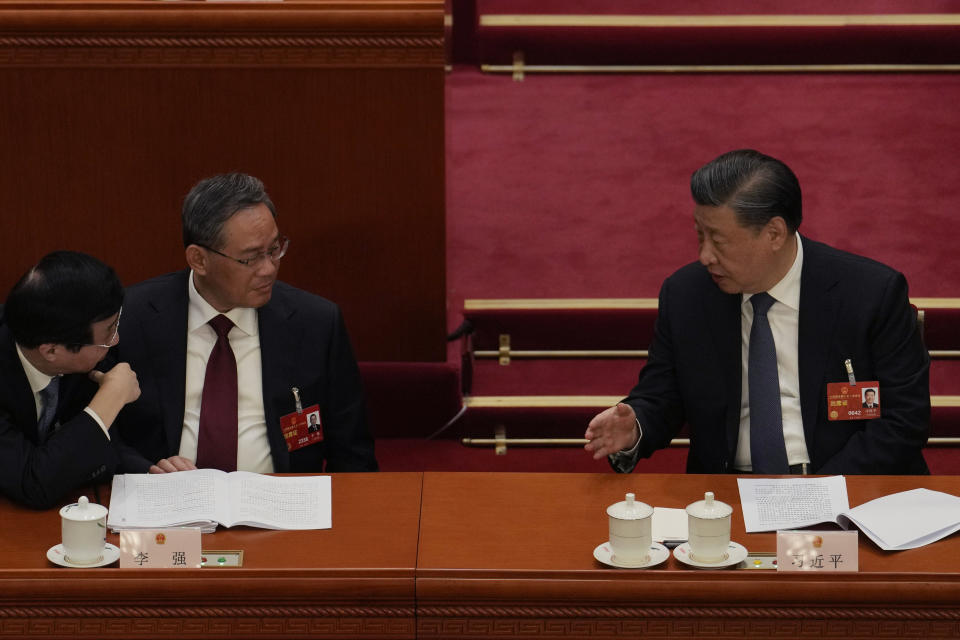 Chinese President Xi Jinping, right, speaks to Politburo Standing Committee members Wang Huning, left, and Li Qiang during a session of China's National People's Congress (NPC) at the Great Hall of the People in Beijing, Tuesday, March 7, 2023. The pro-business track record of the man who is expected to become China's top economic official on Saturday will make Li Qiang's term a test of whether he can moderate President Xi Jinping's tendency to intervene in daily life. (AP Photo/Ng Han Guan)