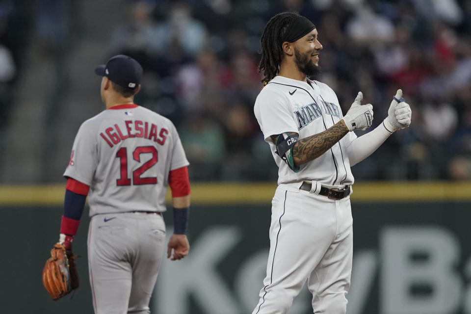 Seattle Mariners' J.P. Crawford, right, reacts next to Boston Red Sox second baseman Jose Iglesias (12) after Crawford hit a double, with fan interference, during the first inning of a baseball game, Monday, Sept. 13, 2021, in Seattle. (AP Photo/Ted S. Warren)