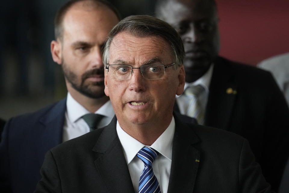 Brazilian President Jair Bolsonaro speaks from his official residence of Alvorada Palace in Brasilia, Brazil, Tuesday, Nov. 1, 2022, the leader's first public comments since losing the Oct. 30 presidential runoff. Behind his Bolsonaro's son Eduardo, a lawmaker. (AP Photo/Eraldo Peres)