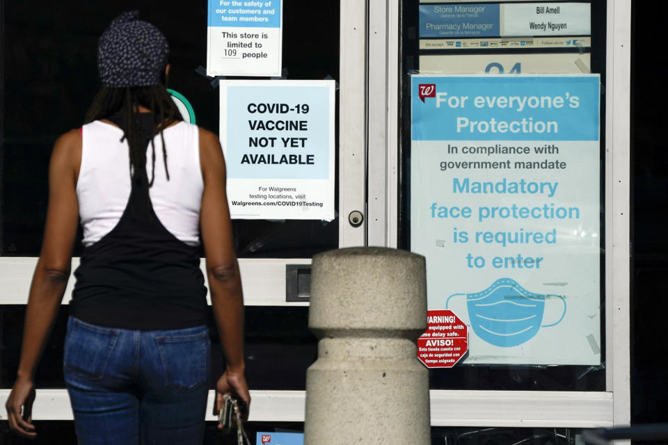 FILE - In this Dec. 2, 2020, file photo, a customer walks past a sign indicating that a COVID-19 vaccine is not yet available at Walgreens in Long Beach, Calif. States faced a deadline on Friday, Dec. 4, 2020, to place orders for the coronavirus vaccine as many reported record infections, hospitalizations and deaths, while hospitals were pushed to the breaking point — with the worst feared yet to come.(AP Photo/Ashley Landis, File)